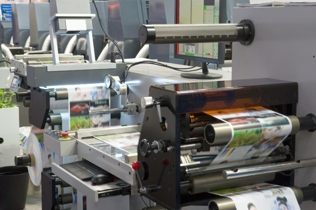 Image of a busy digital printers with a humidifier poised over the printer.