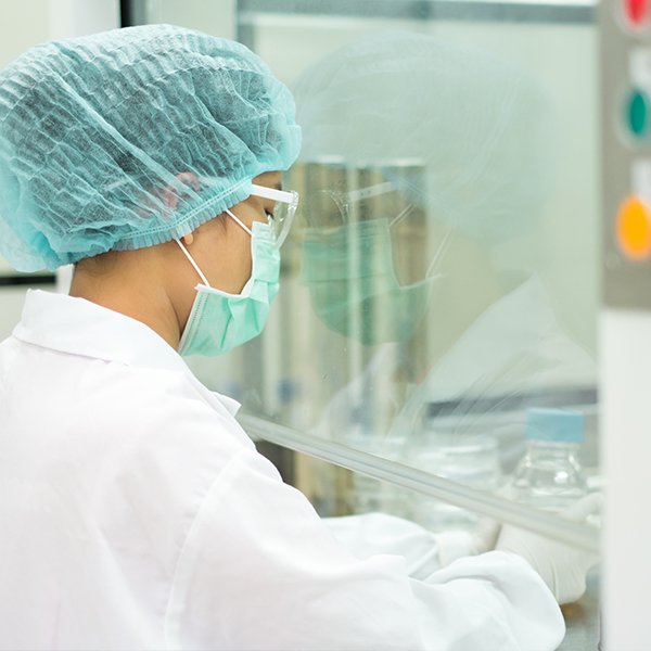 User using a cleanroom to inspect items within a controlled environment