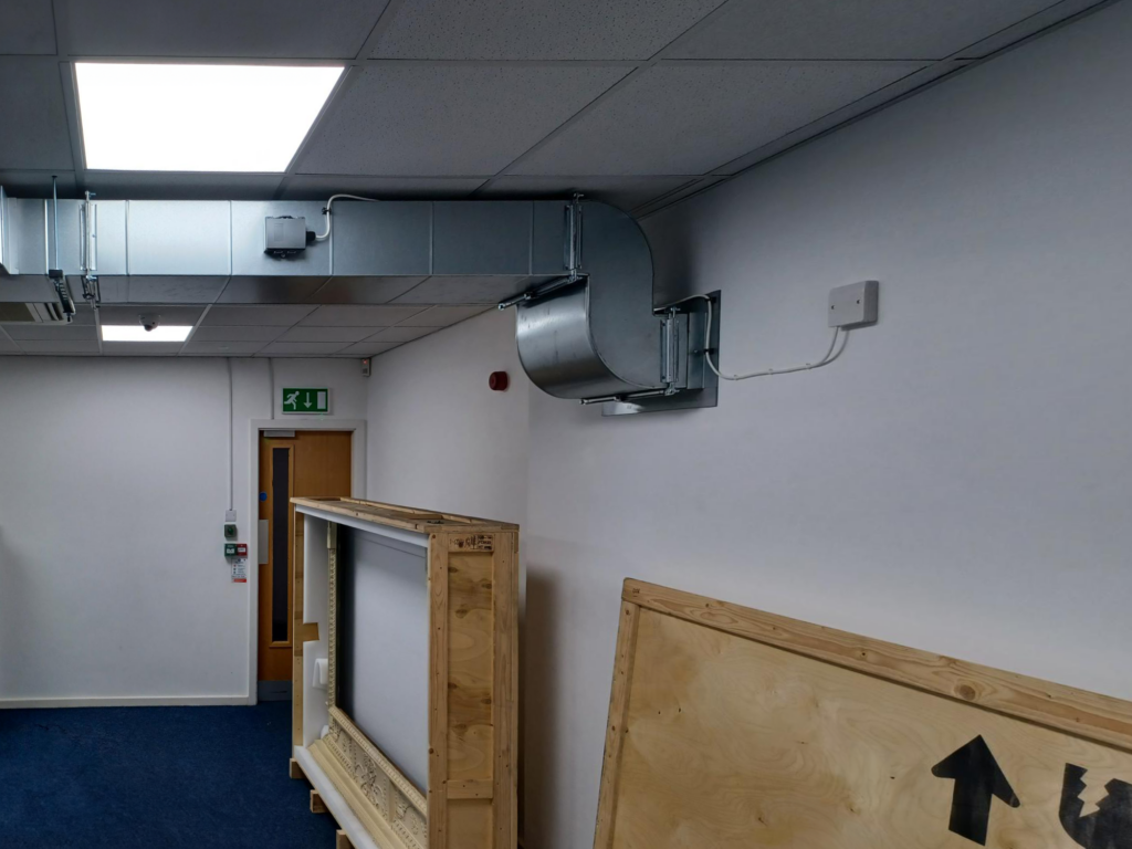 Close up of the new galvanised steel ductwork against the ceiling and end wall of the art storage room at Air Sea Packing